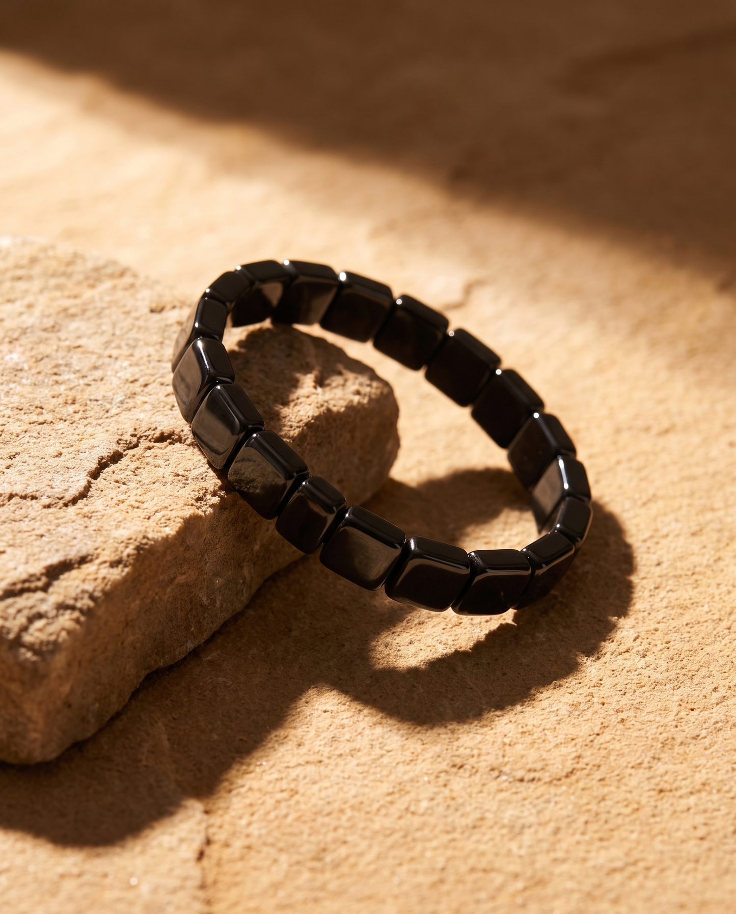 AurumStone Balans en Stijl Armband, premium hero-opname op zandsteen met hard zonlicht