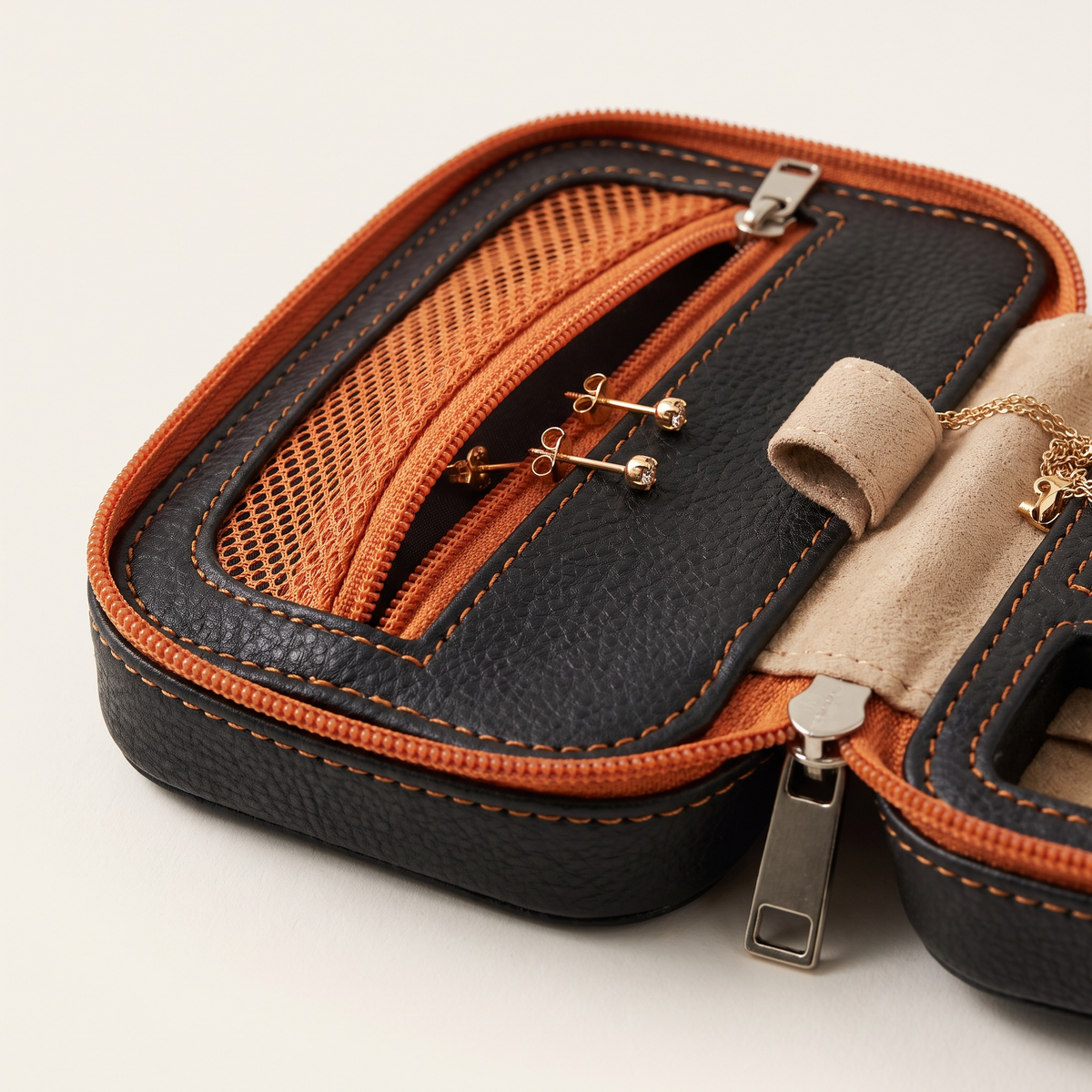 Detailfoto van een gaasvakje met oorbellen en een stoffen kettinghaakje met ketting